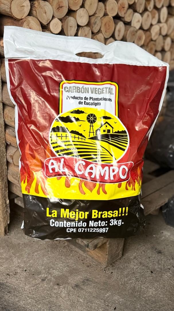 Saco de carbón vegetal Al Campo frente a troncos de eucalipto